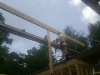 Carpenter setting a ridge beam over a new addition frame — Ice Dam Removal by Roofing Brothers in Fort Dodge